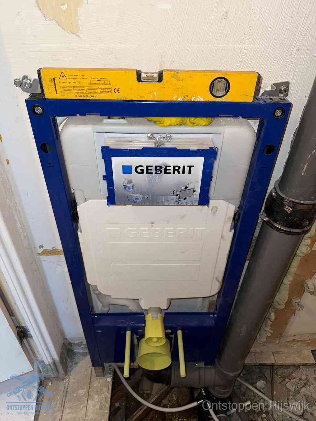 Een Geberit inbouwreservoir met frame voor een hangtoilet tegen de wand, met de afvoerbocht naar de vloer, kenmerkend voor een verstopt hangtoilet in Rijswijk