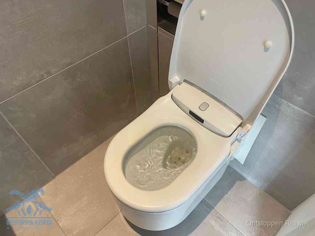 Een toiletpot vol troebel water met drijvend papier en restanten, de meest voorkomende oorzaak van een verstopte wc in Rijswijk