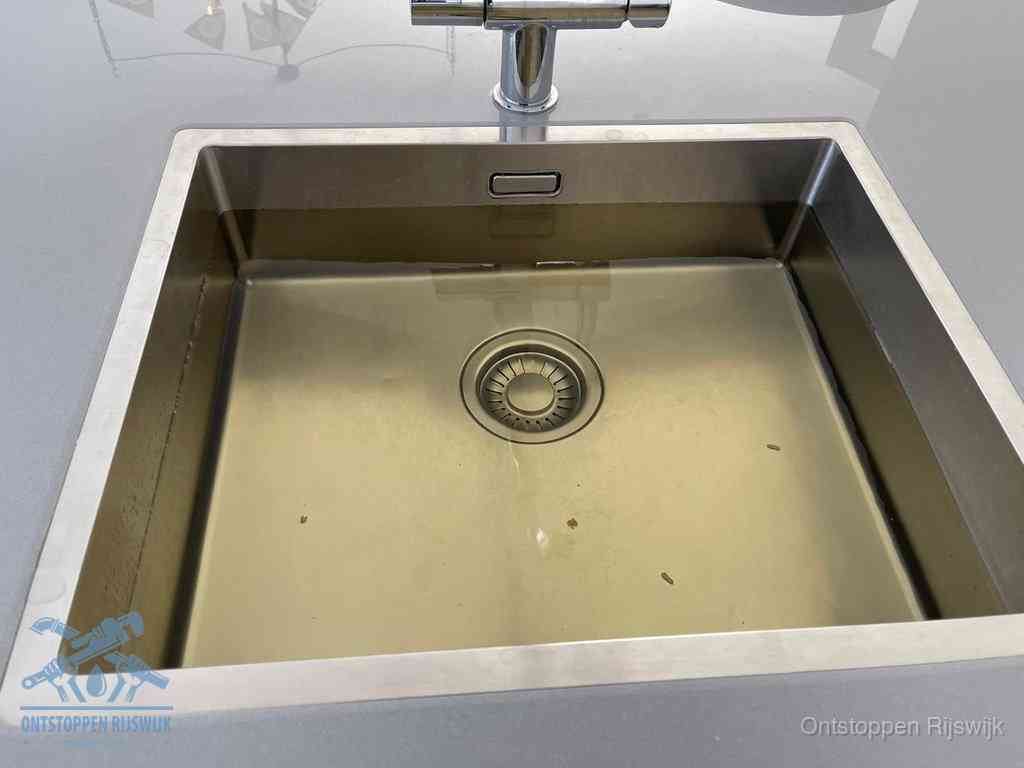 Stilstaand water in een rvs spoelbak dat niet wegloopt, een duidelijk signaal van een gootsteenverstopping in Rijswijk